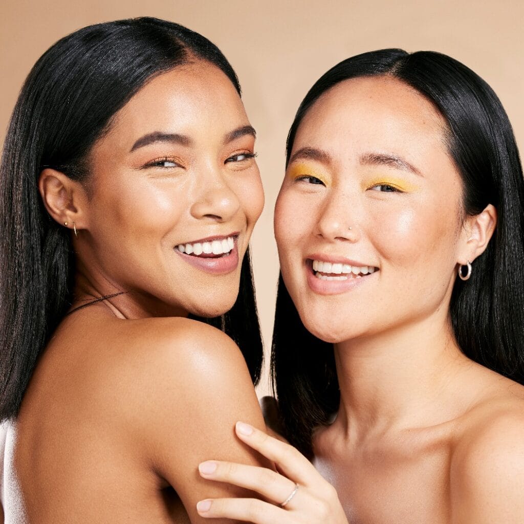 Beauty, makeup and portrait of women in studio for wellness, hygiene and grooming on brown background. Face, friends and eyeshadow by girl for different, skin and luxury skincare, relax and isolated