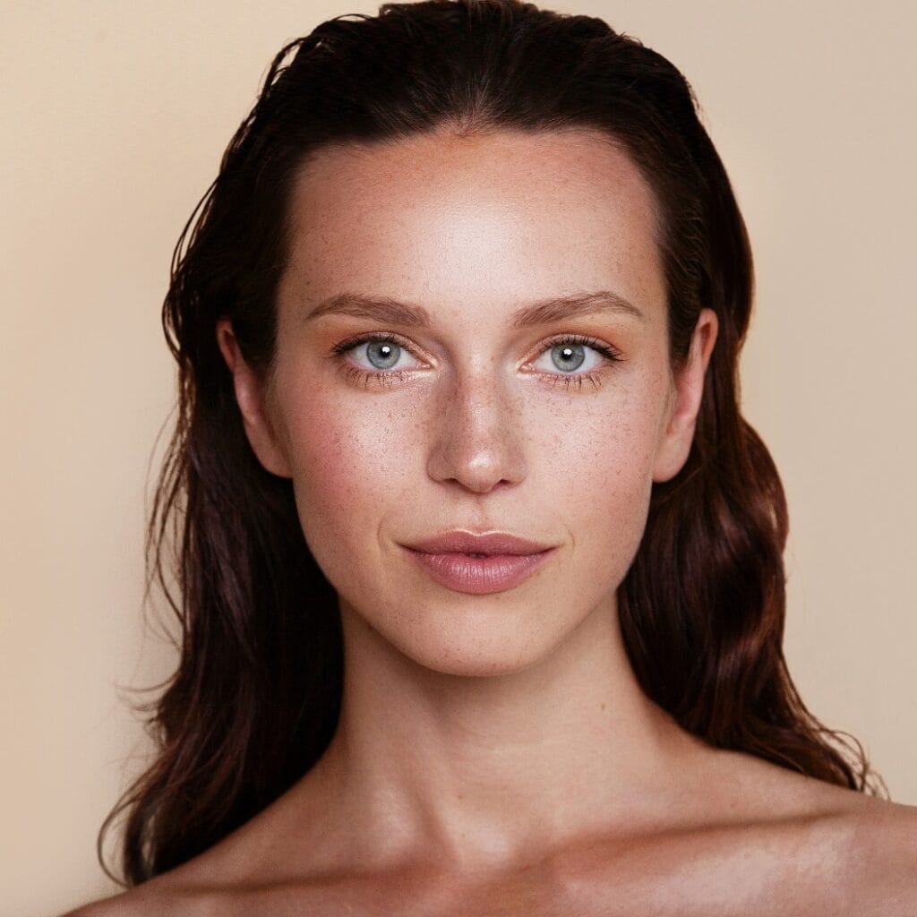 Beauty woman portrait. Beautiful spa model girl with perfect fresh clean skin. Youth and skin care concept. Beige background. Nude makeup